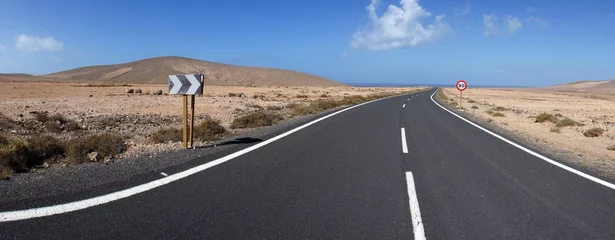 Schilderijen op glas Road  route through rocky and volcanic desert. Near Los Molinos, Fuerteventura, Canary Islands. Empty way, travel photo. © geografika