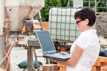 Civil engineer with a laptop on site