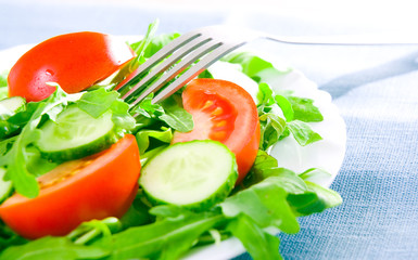 Fresh salad with tomatoes, rucola and cucumbers