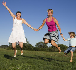 Girlfriends and little boy having fun outdoors