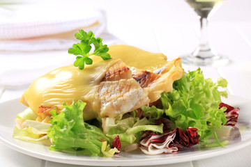Cheese topped fish fillets with salad