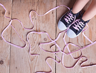 The problem - childs feet and long twisted shoelaces - obrazy, fototapety, plakaty