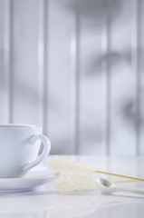 white ceramic cup and sugar stick