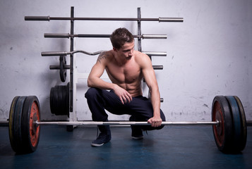 An athlete is preparing to lift a heavy dumbbell