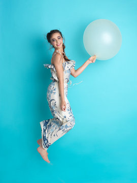 happy young woman jumping with balloon