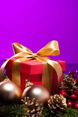 Red present box in a purple Christmas setting