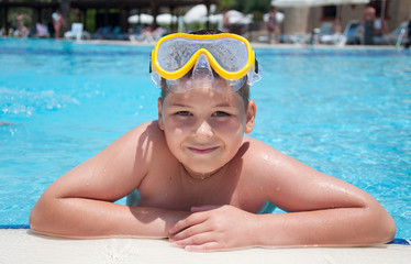 Boy with a mask for snorkeling in the pool