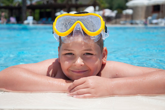Boy with a mask for snorkeling in the pool