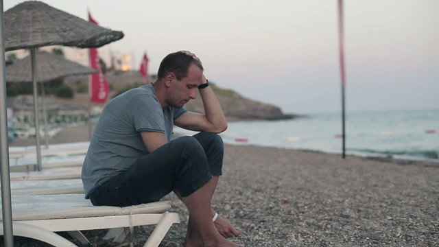 Young sad, depressed man on the beach
