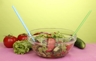 Fresh salad with tomatoes and cucumbers on green background