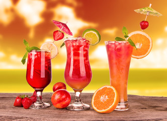 Summer cocktails in sunset with blur beach on background