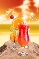 Summer cocktails in sunset with blur beach on background
