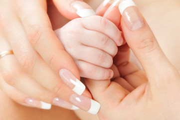 Mother holding her Baby's hands .