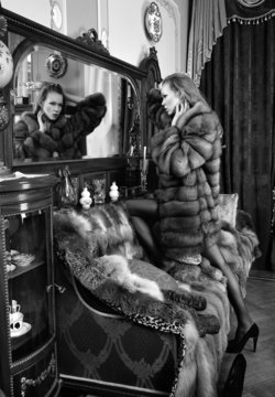 woman in fur coat  at the mirror in  Luxurious classical interio