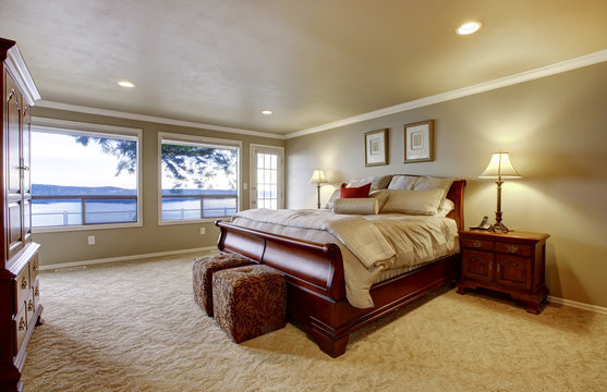 Large bedroom with wood bed and water view.