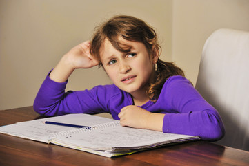 Naklejka premium a young girl a troubled doing her homework