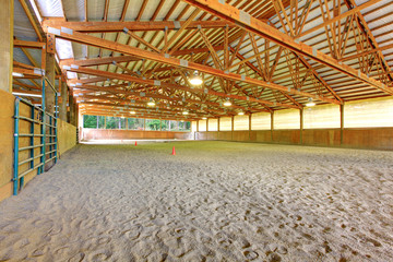 Large horse arena riding area with sand interior.