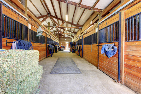 Horse stable interior with hey and wood doors.