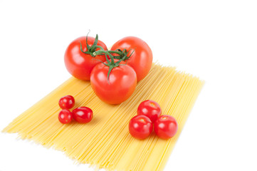 Raw spaghetti noodles and variety of ripe tomatoes