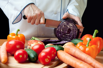 Horizontal shot of chef's hands cutting red cabbage head