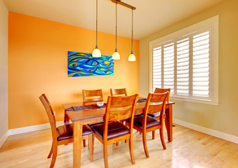 Dining room with blue painting and wood table.