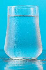 glass of fresh water over blue background