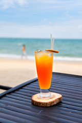 Orange juice in glass with ice, straw and fruit slice