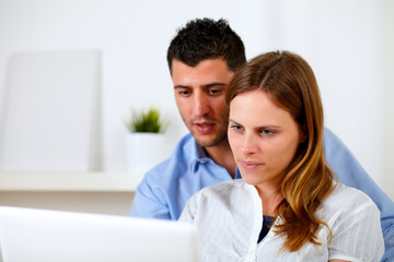 Attractive young couple using laptop together