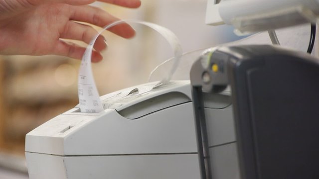 female hand takes checks from the cash register