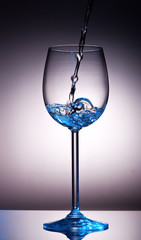 Small amount of transparent liquid in wine glass