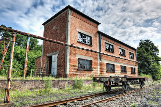 Abandoned railcar in front of an old industrial building
