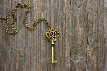 antique golden key over wooden background