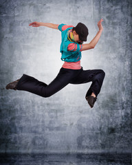 Fototapeta na wymiar modern style dancer posing behind studio background