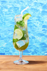 cold fresh lemonade on wooden table on sea background