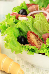Salad with sun dried tomatoes and prosciutto ham