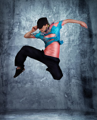 Fototapeta na wymiar modern style dancer posing behind studio background