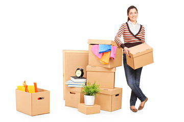 Smiling woman moving into a new home with many boxes around her