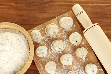 Raw Dumplings on cutting board on wooden background close-up