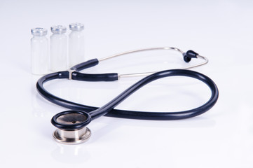 Medical stethoscope and three vials for injection