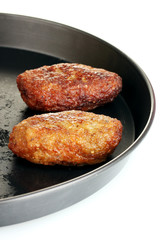 Tasty burgers in the pan on white background close-up