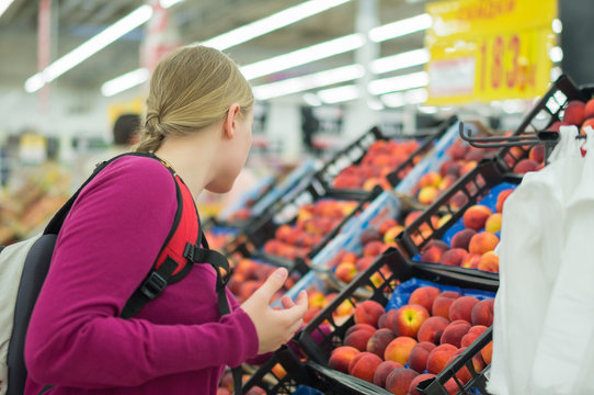 Woman choose red apples in supermarket