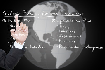 Hand pushing business strategic planning on the whiteboard.