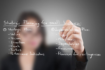 Business lady write strategic planning on the whiteboard.