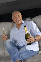 Señor turista bebiendo champagne en una limosina,en un auto.