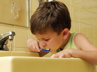 Niño cepillándose los dientes en un baño.lavando los dientes.