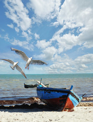 Urlaubs-Erinnerung: Strand mit Fischerboot und Möwen