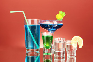 a variety of alcoholic drinks on red background