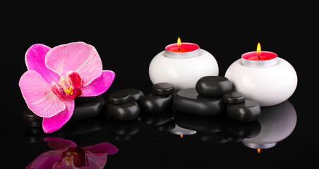 Obraz na płótnie Canvas Spa stones with orchid flower and candles isolated on black