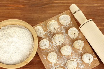 Raw Dumplings on cutting board on wooden background close-up