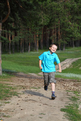 Happy boy runs near the forest